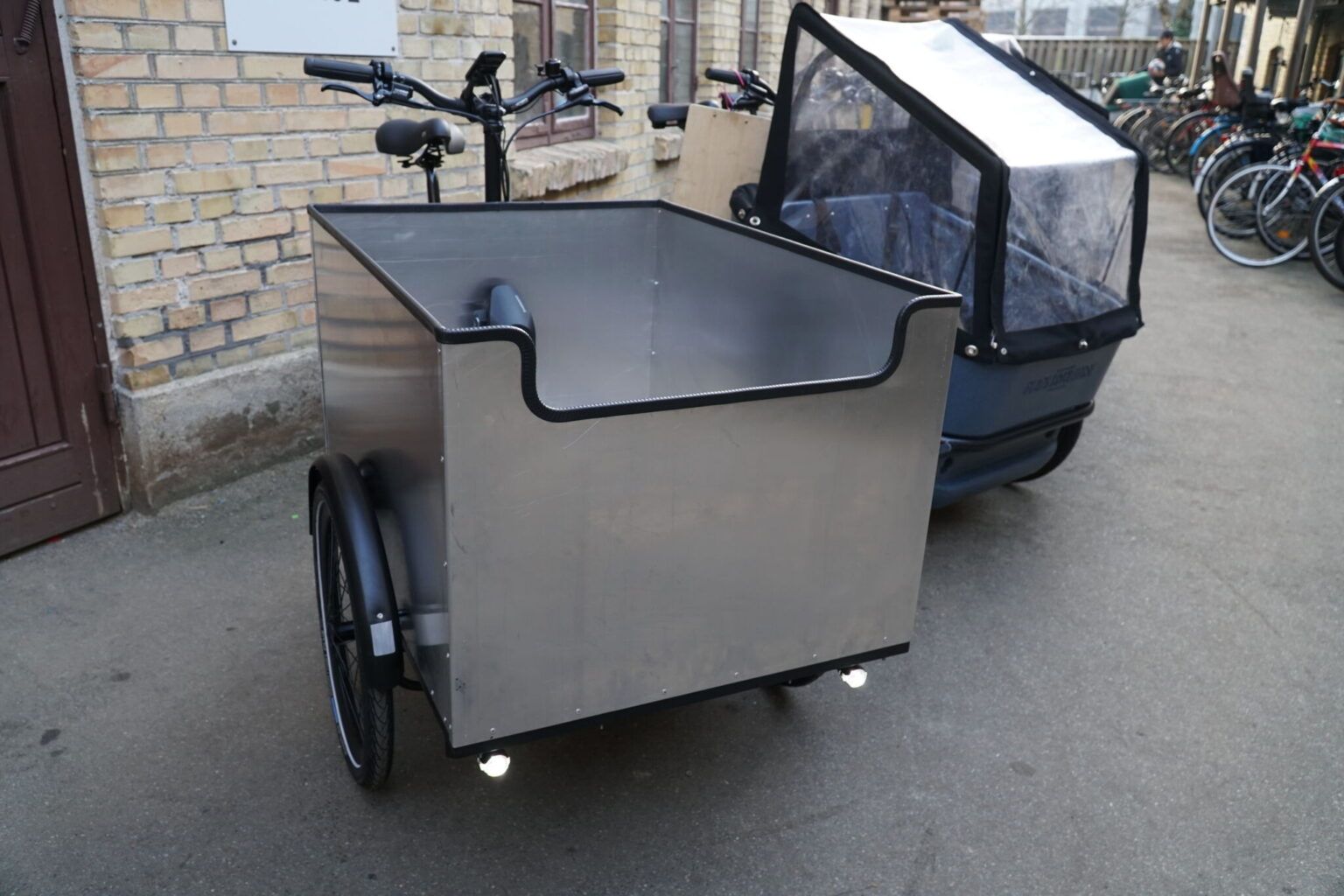 Photo of the OX cargo bike with an aluminium cargo box and no lid.