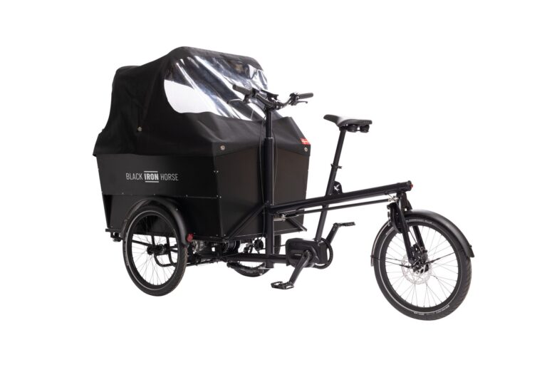 Left side of rear wheel steered cargo bike for six children with the rain cover up