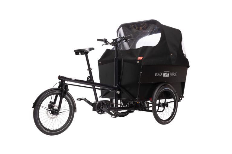 Black rear wheel steering cargo bike with a large box for six children turned to show back wheel
